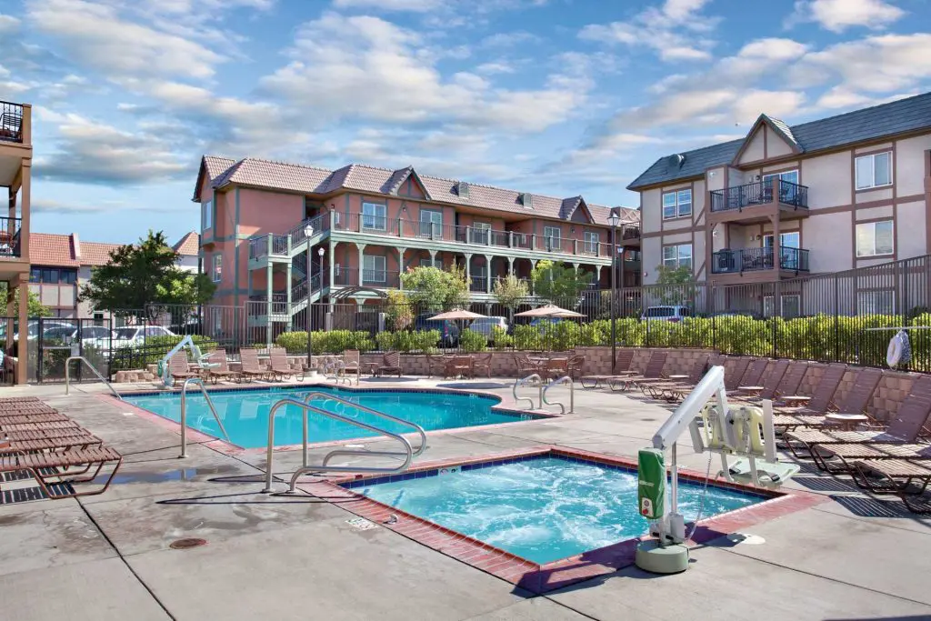 The WorldMark Solvang pool and spa, loungers set out with the resort buildings behind