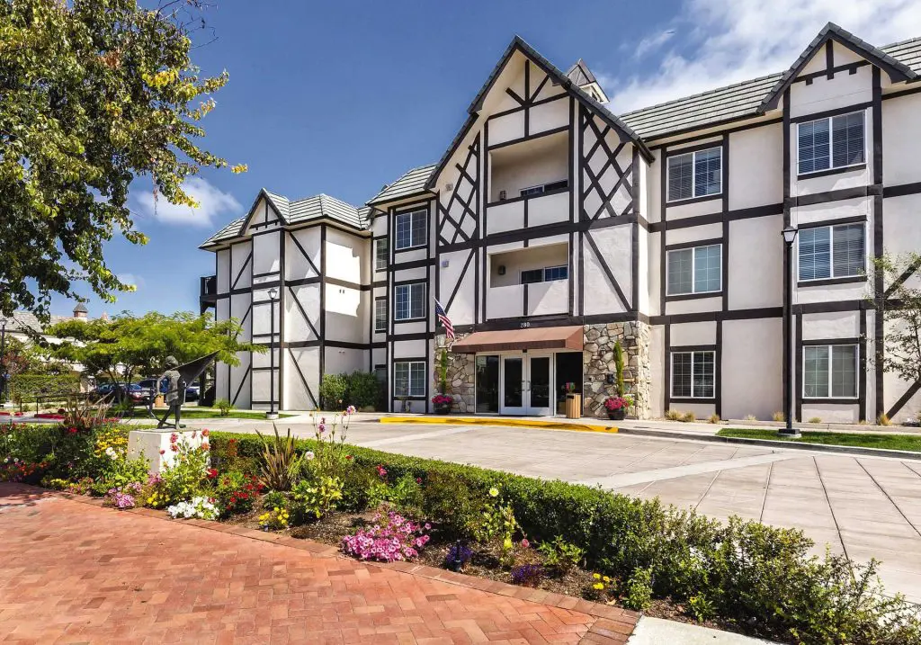 The half-timbered three-storey front of WorldMark Solvang above its flower borders